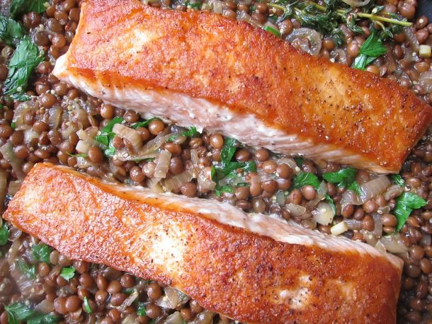 Cooked salmon fillets served with lentils and garnish