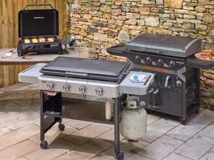 Three flat-top grills on an outdoor patio. 