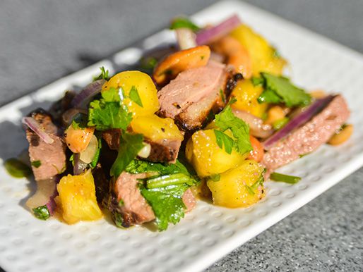 The finished salad is served on a square white plate.