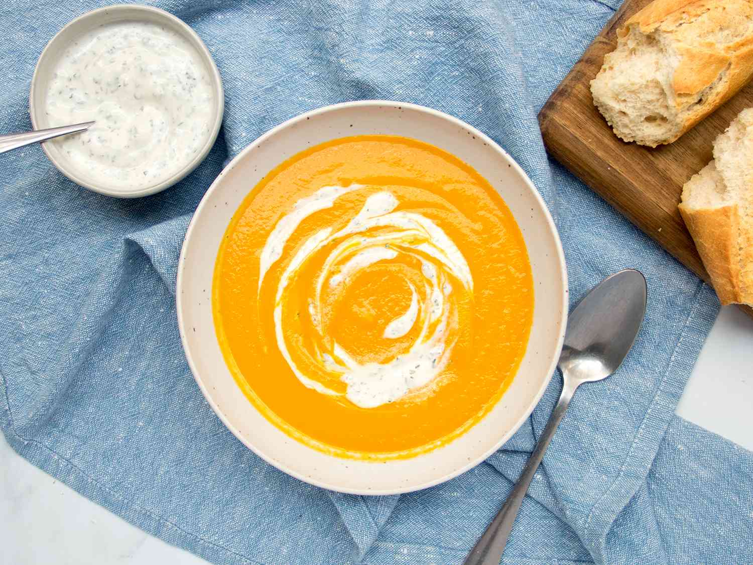 Carrot soup spooned into a white bowl.