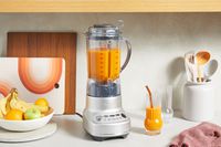 The Breville Fresh & Furious Blender set on a counter full of juice