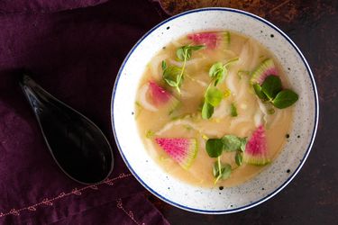 Overhead view of a bowl of miso soup with mixed seasonal vegetables.