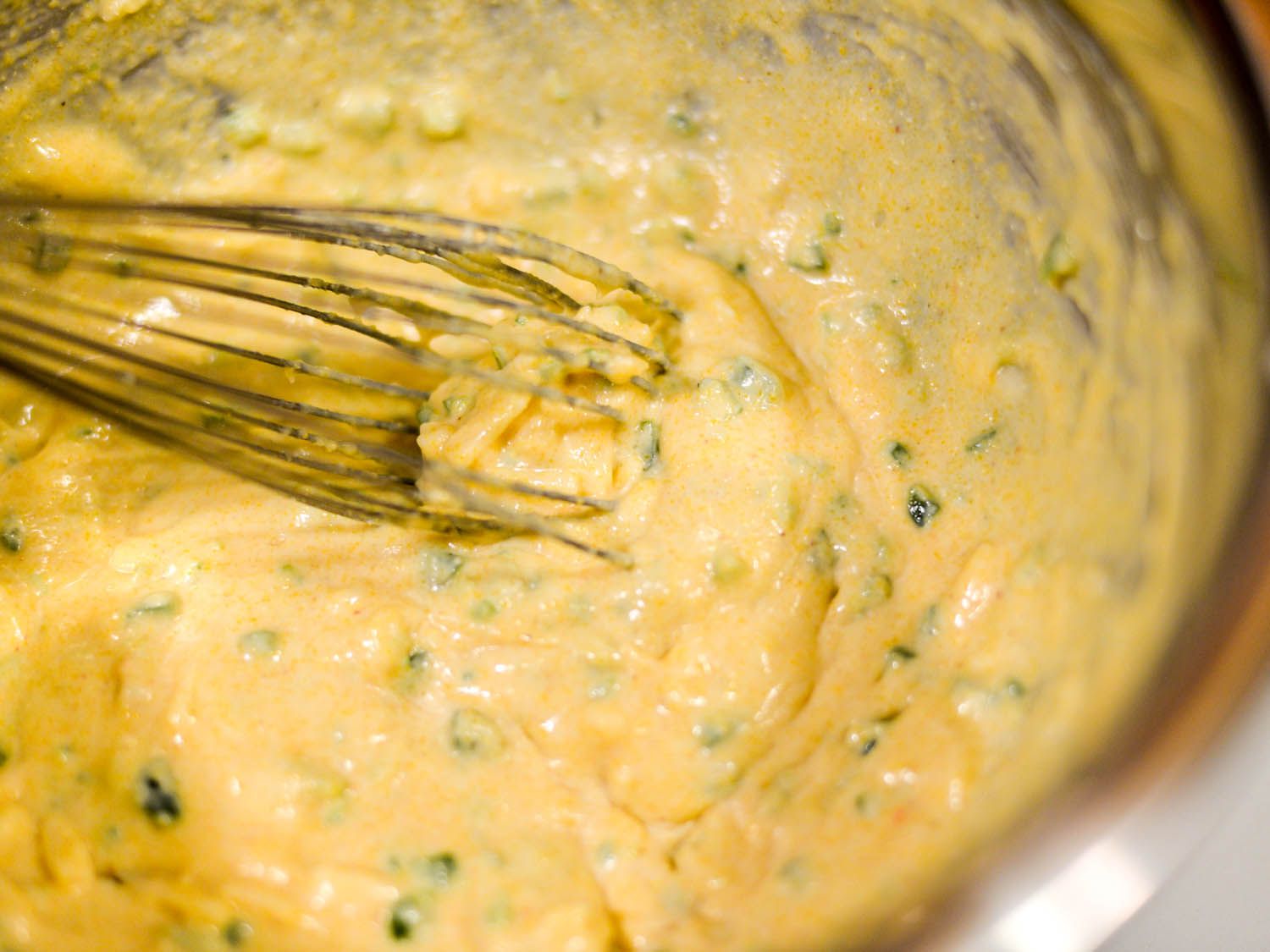 Whisking ingredients for cornbread until well combined.