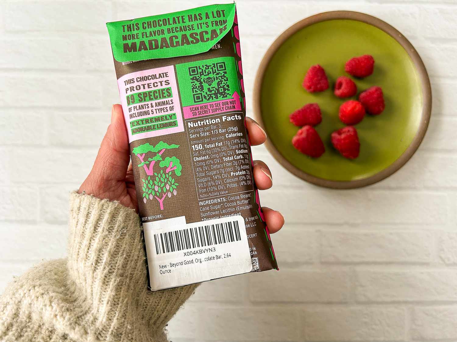 A hand holding the Beyond Good Pure Dark 70% showing the nutrition facts