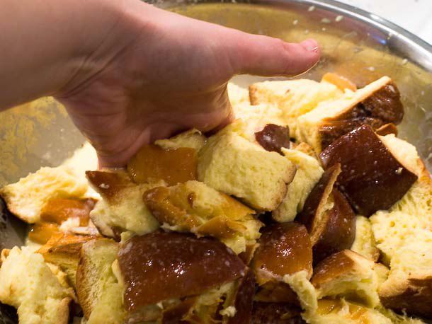 Tossing around custard soaked bread chunks in a large bowl. 