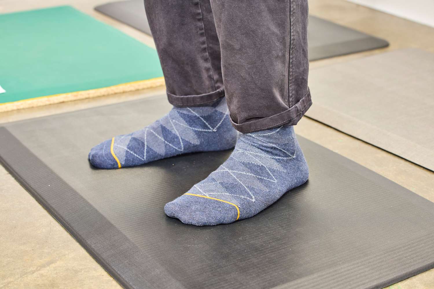 A person stands on the ComfiLife Anti-Fatigue Floor Mat