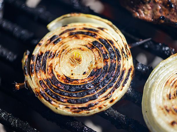 Close-up of well-charred onion halves on a grill