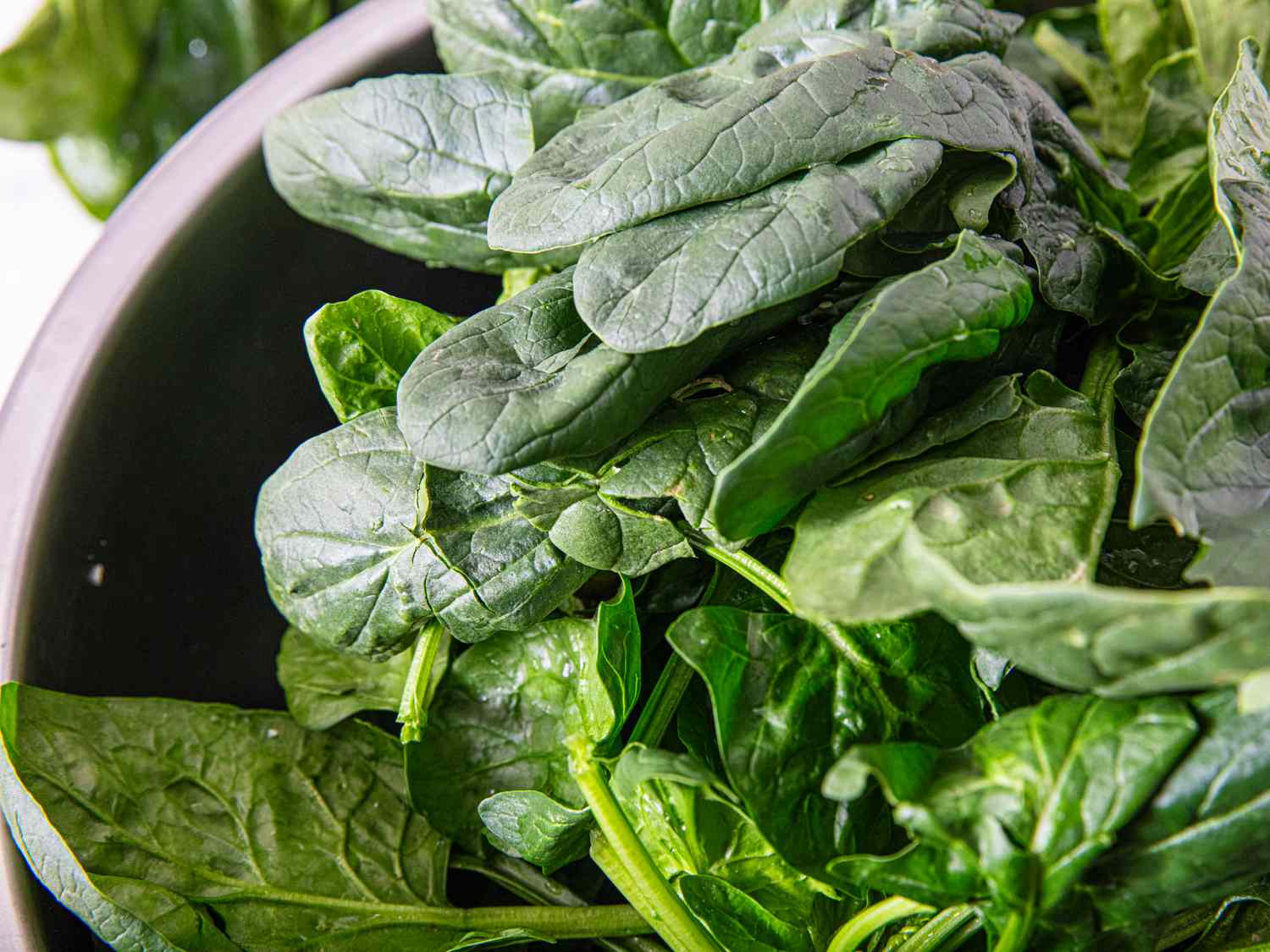 A bowl filled with fresh spinach leaves