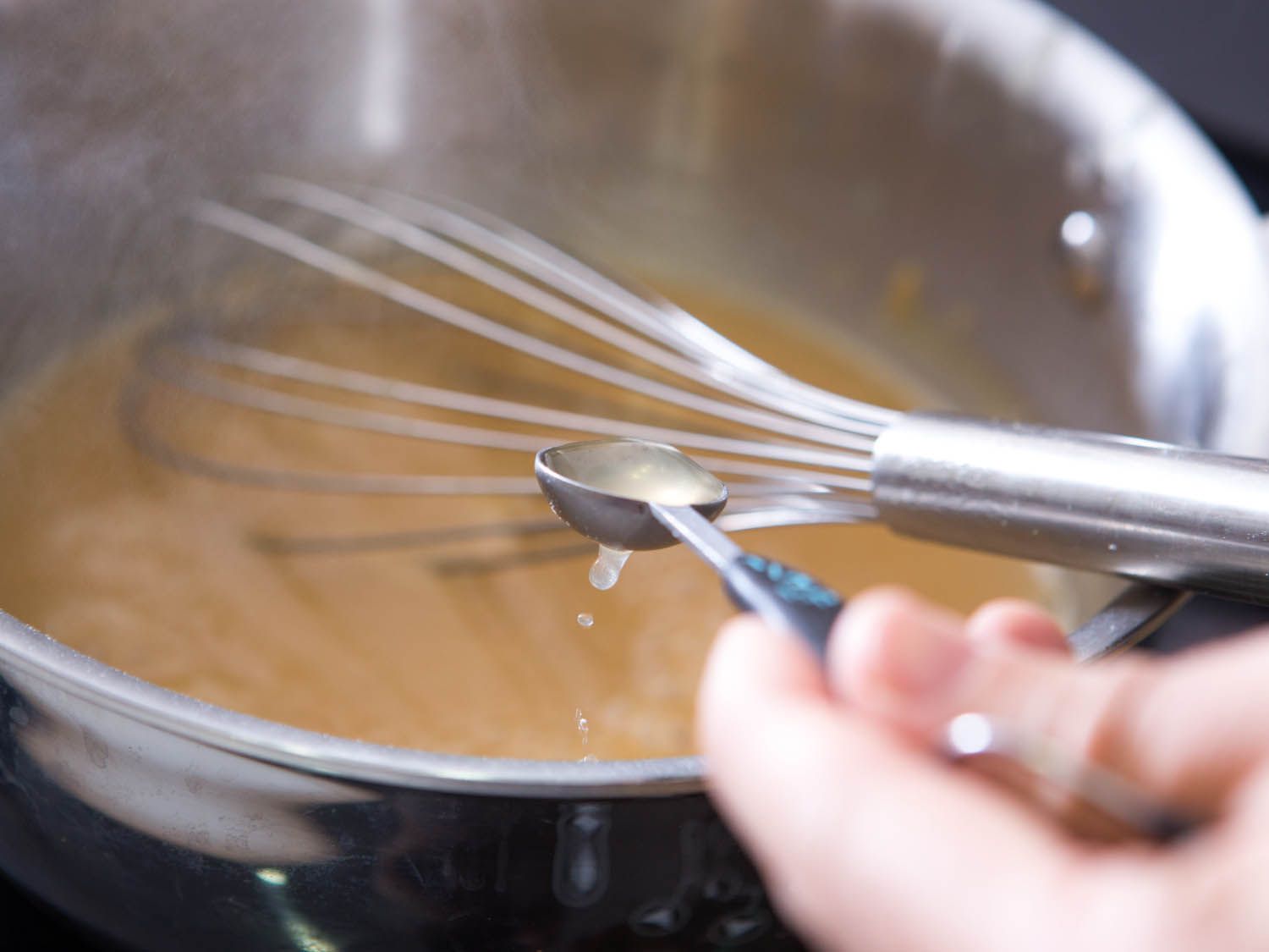 Whisking a teaspoon of cider vinegar into gravy for Swedish meatballs.