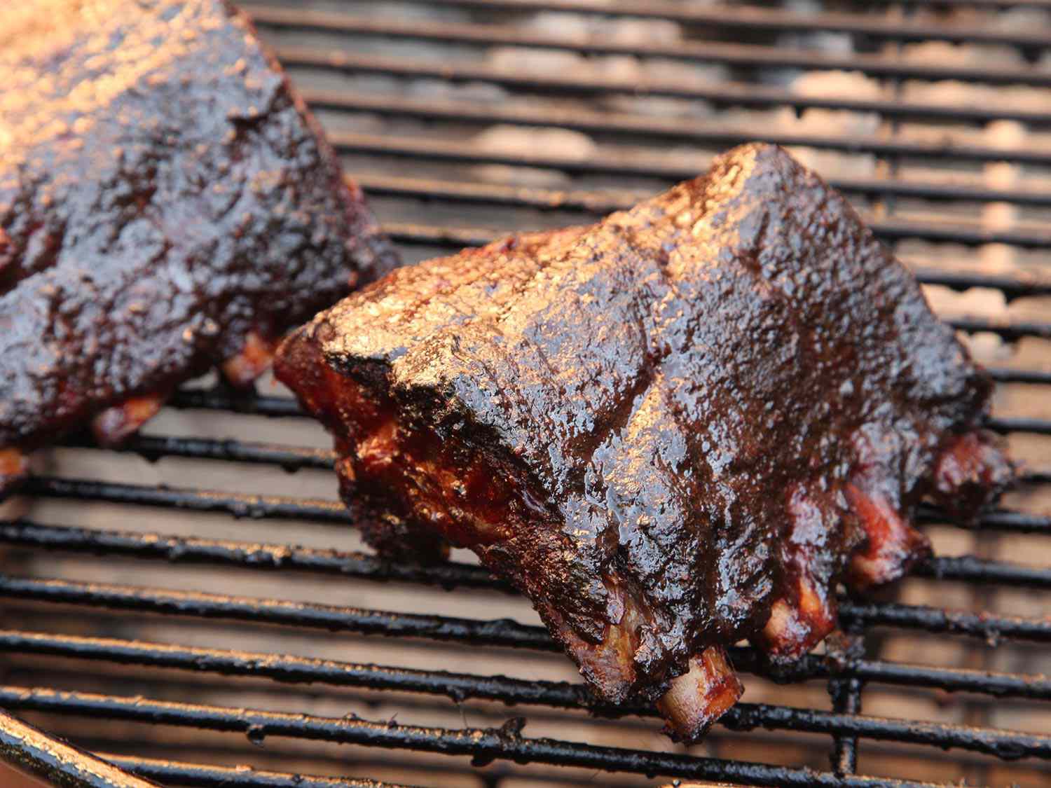 A portion of a rib cooking on a grill.