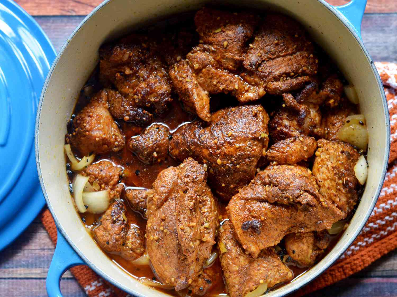 Overhead view of the braised, chorizo-spiced pork shoulder in a Dutch oven, ready to be shredded.