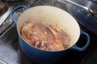 Le creuset dutch oven with a seared pork shoulder inside