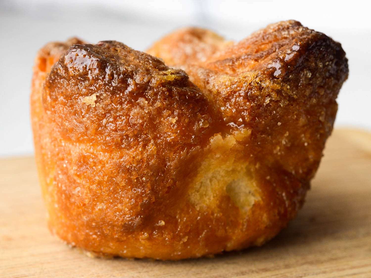 Side view of kouign amann on cutting board.