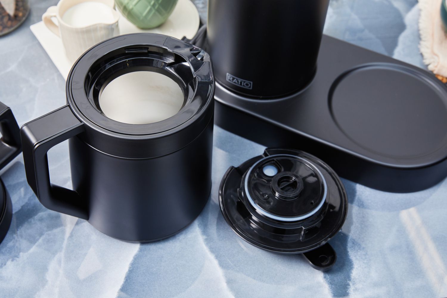 The carafe of the Ratio Six Coffee Maker.with its lid next to it 