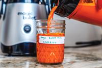 Carrot juice being poured from the Magic Bullet juicer