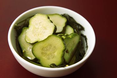 Closeup of a small bowl filled with quick dill pickle chips.
