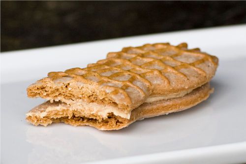 Side view of a homemade Nutter Butter cookie sandwich with a bite missing.