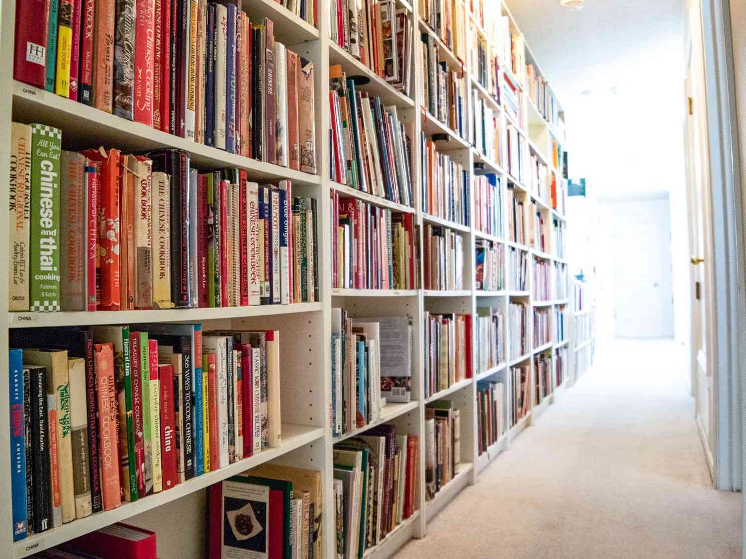 A hall with long shelves full of cookbooks.