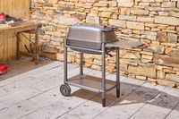 The PK Grills Original PK300 Grill & Smoker outdoors near stone wall