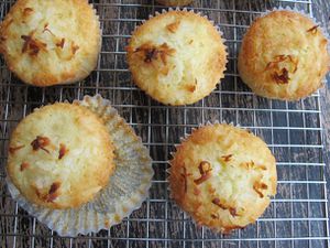 Overhead closeup view of pineapple coconut muffins, cooling on a rack.