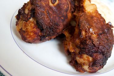 Closeup of green chile buttermilk fried chicken, served on a white plate.