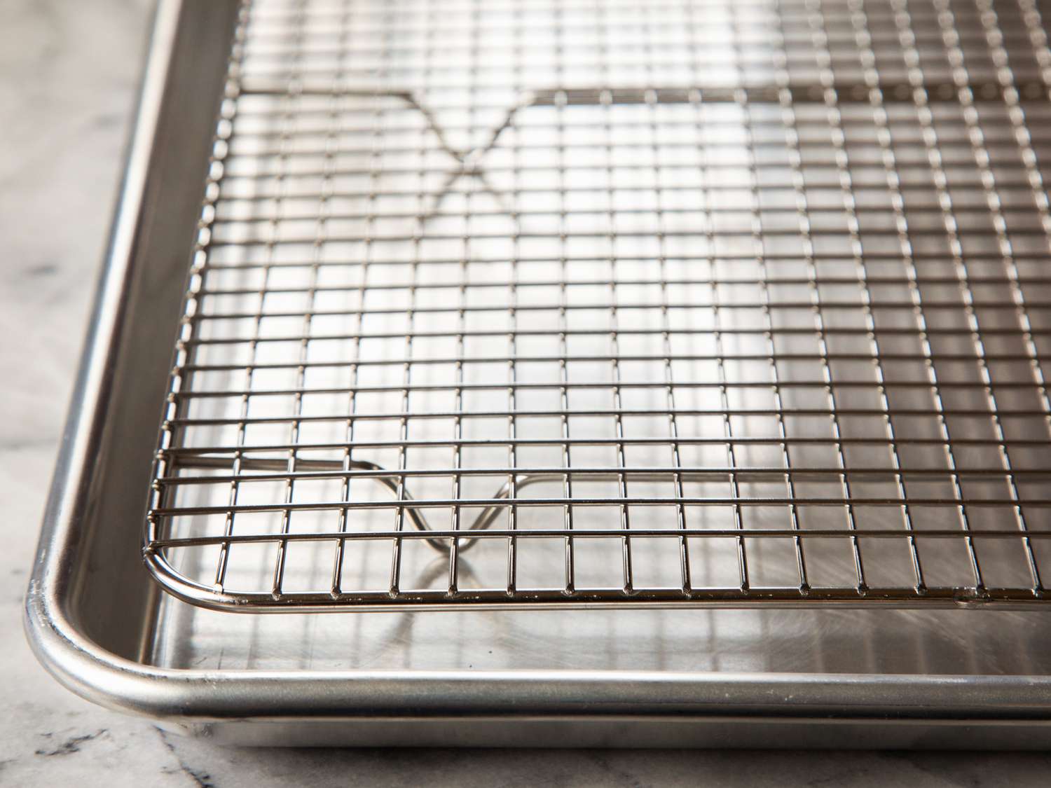 a closeup of the end and and center supports of a cooling rack in a half sheet pan.