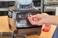 A close-up of a hand turning a nob on the Vitamix 5200 Professional-Grade Blender