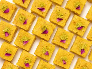 Baklava cake squares lined up on a white surface 