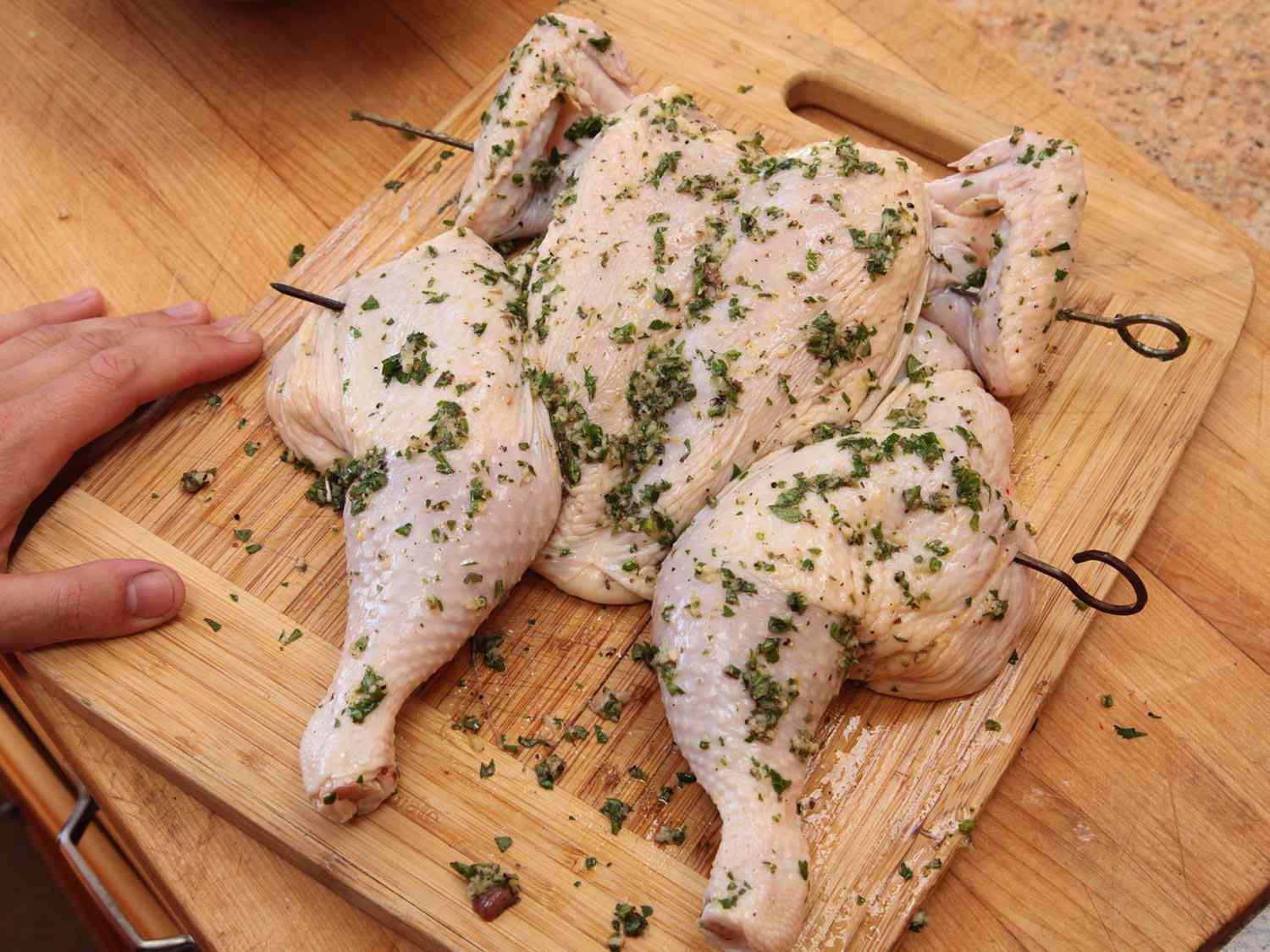 A butterflied chicken after being rubbed with olive oil and herb marinade.