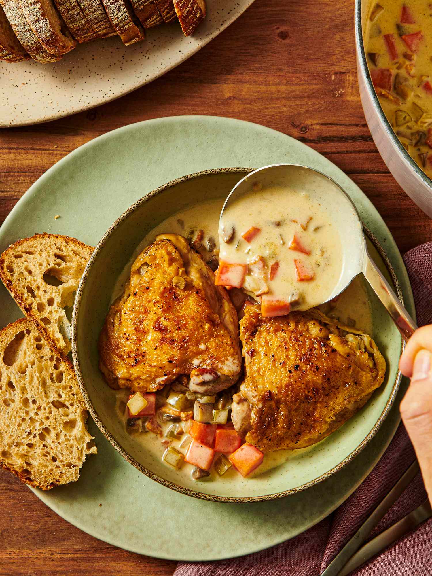 A bowl of Blanquette de Poulet with bread on the side