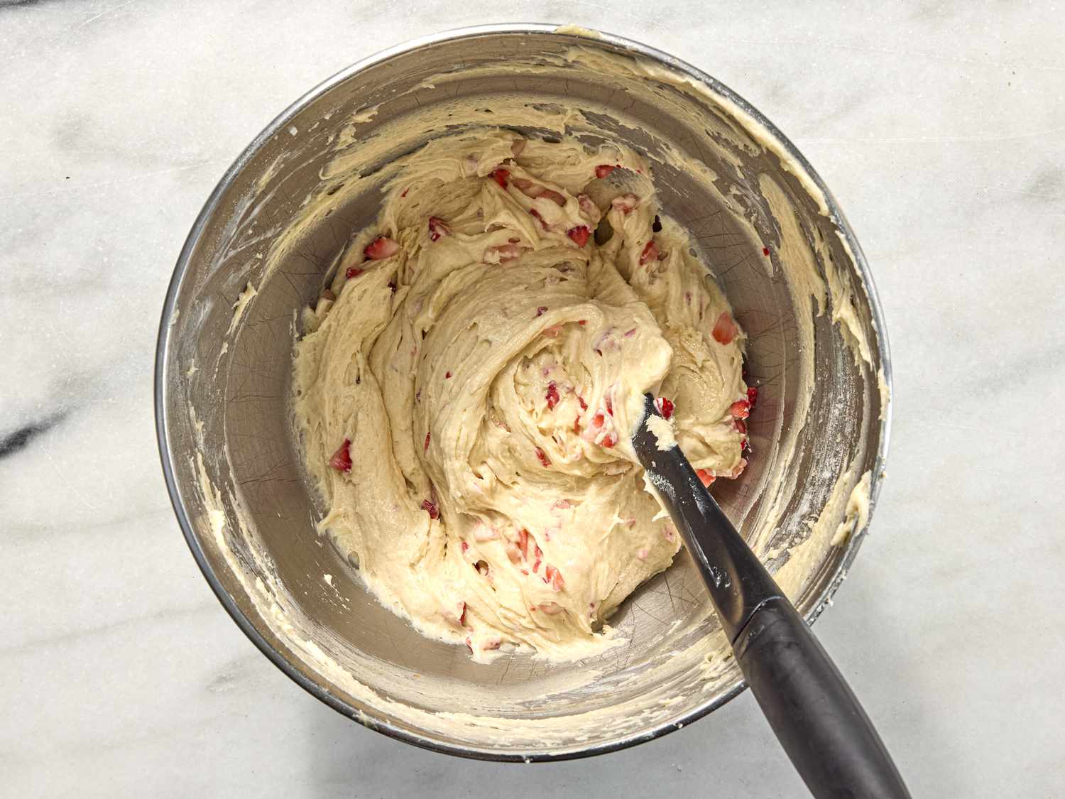 folding strawberries into batter 