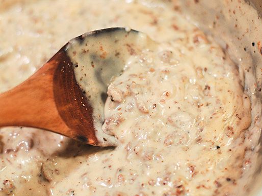 The browned sausage is stirred back into the thickened gravy.