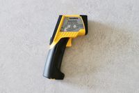 an infrared thermometer on a grey surface