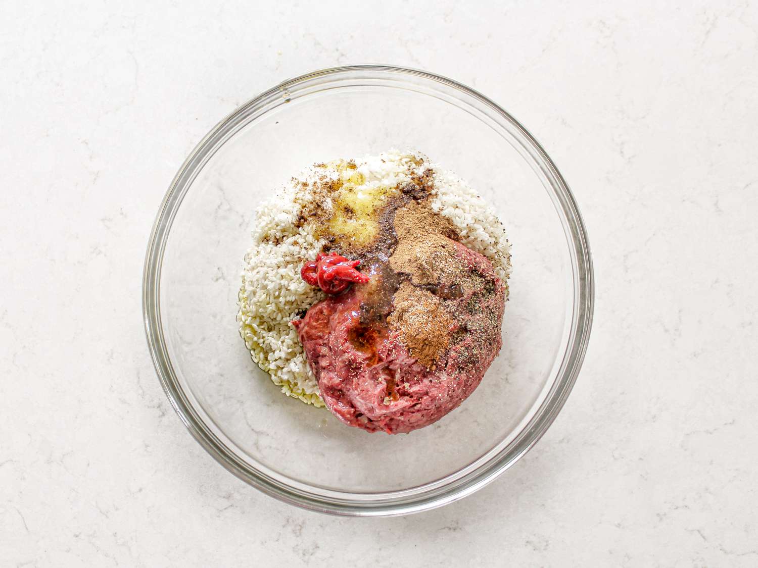Ingredients for meat mixture inside grape leaves in a glass bowl 