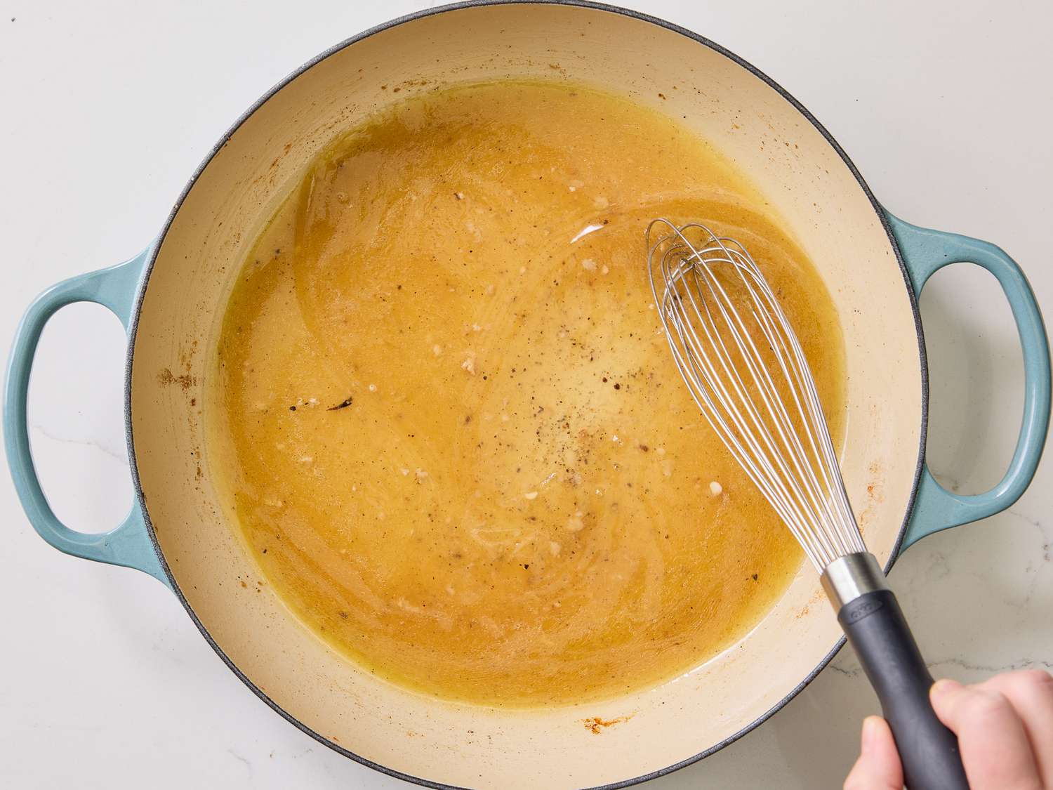 whisking together wine and salt and pepper into skillet 