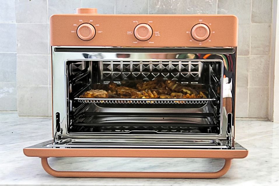 A toaster oven on a kitchen counter, with a tray of food inside