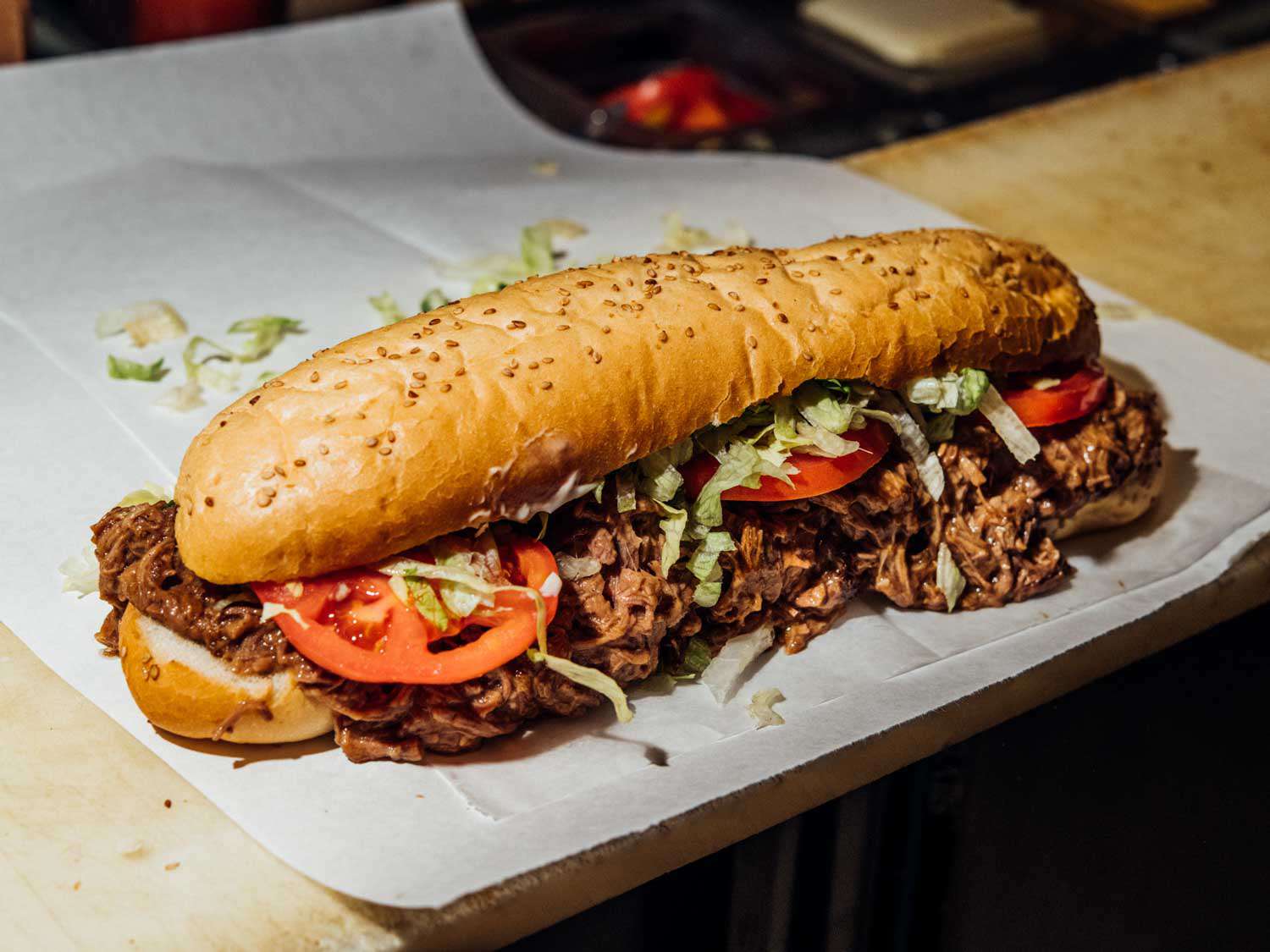 Verti Marte's po'boy with tomato slices and shredded lettuce on sandwich paper.