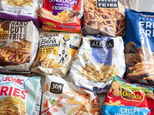 A variety of frozen French fry brands arranged on a surface showcasing their packaging designs