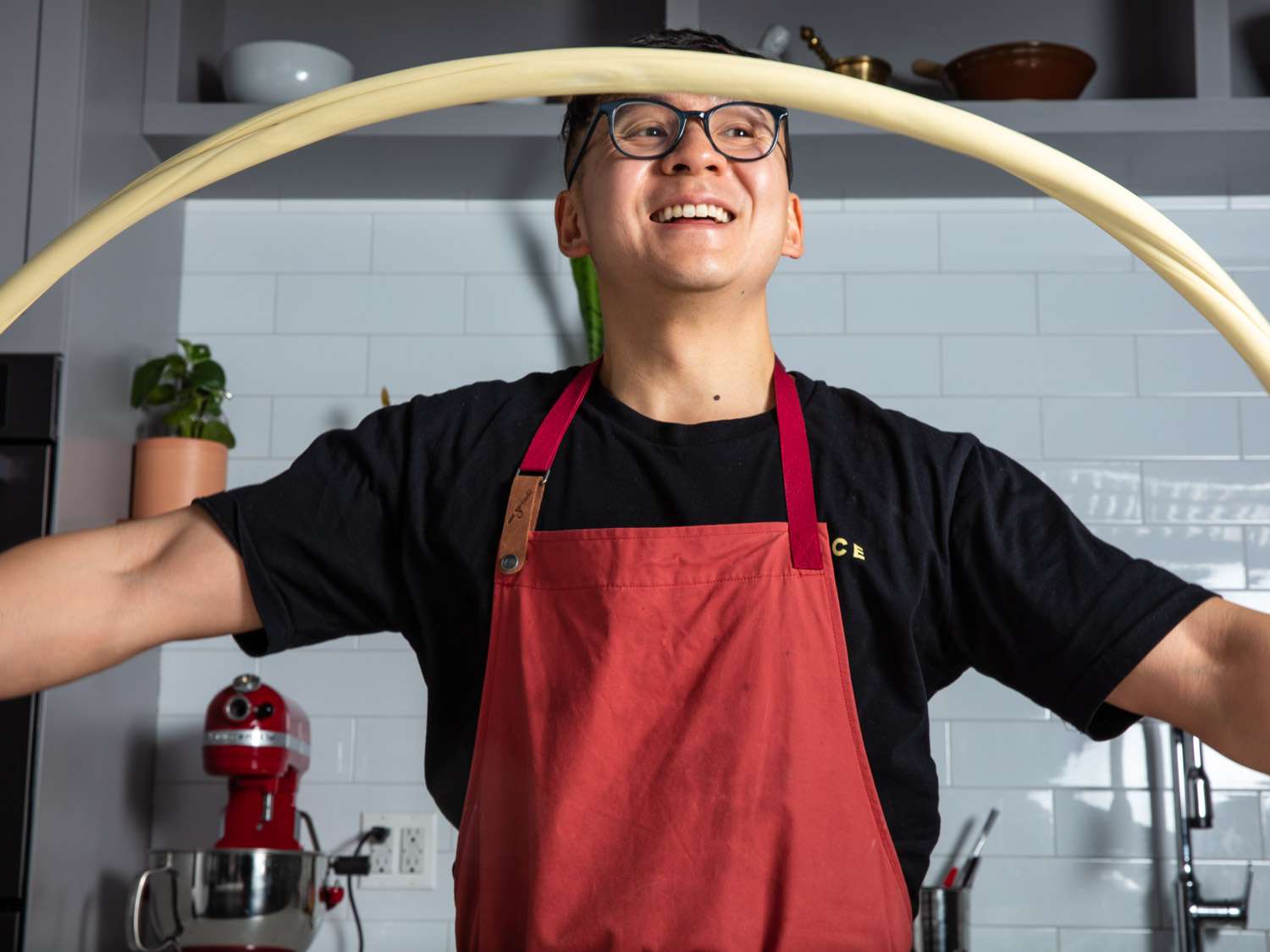 Stretching hand pulled noodle dough into the air.