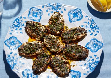 Cooked chermoula sardines arranged on a decorative plate with a garnish