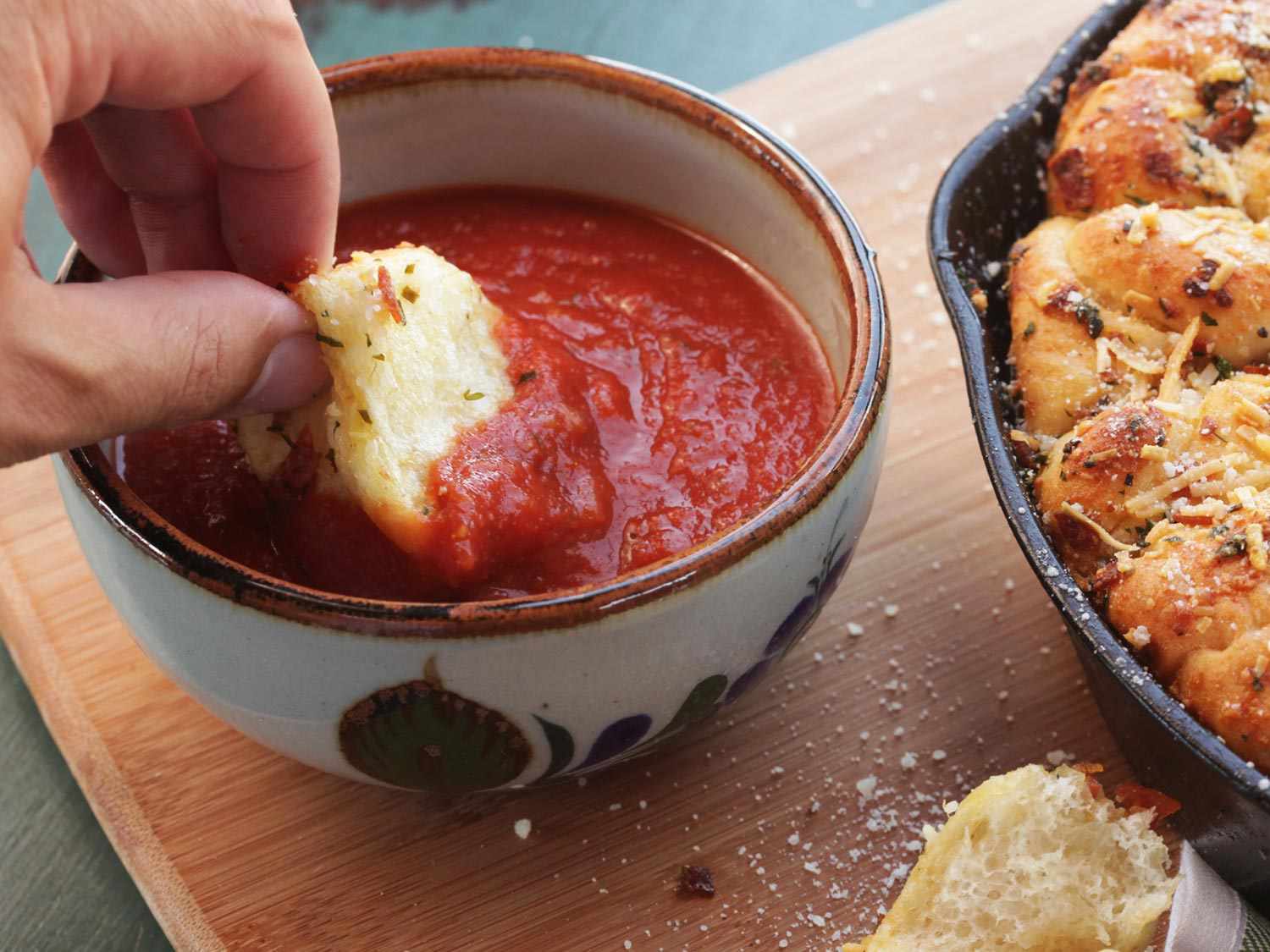 Dipping a pepperoni garlic knot into marinara dipping sauce