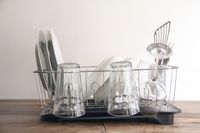 The Rubbermaid dish rack holding a variety of dishes and glassware.