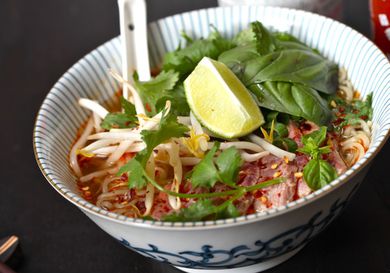 A bowl of Faux Pho, garnished with cilantro, bean sprouts, and a lime wedge.