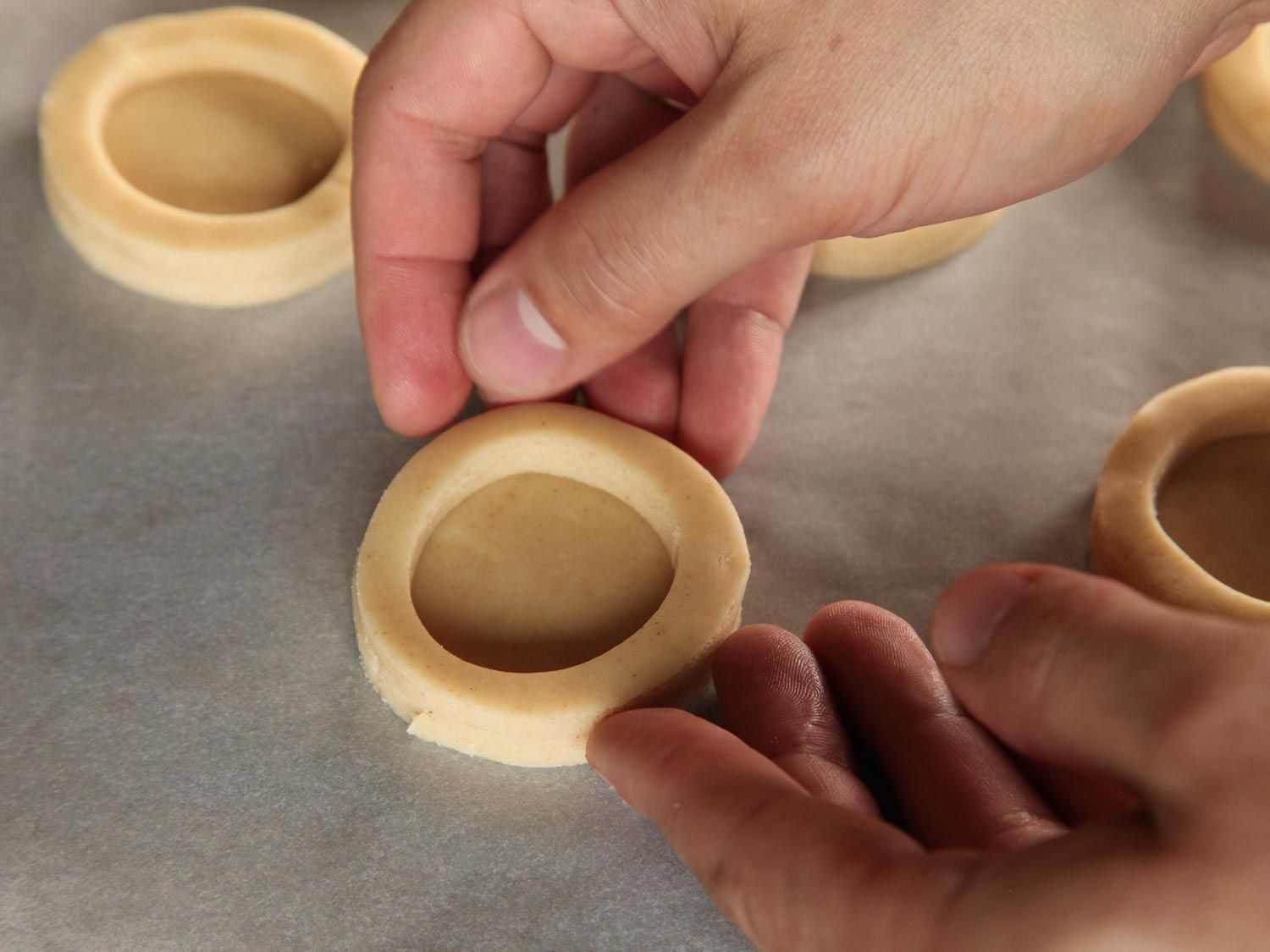 Laying dough rings on top of dough disks