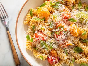 Bowl of pasta with roasted vegetables and grated cheese