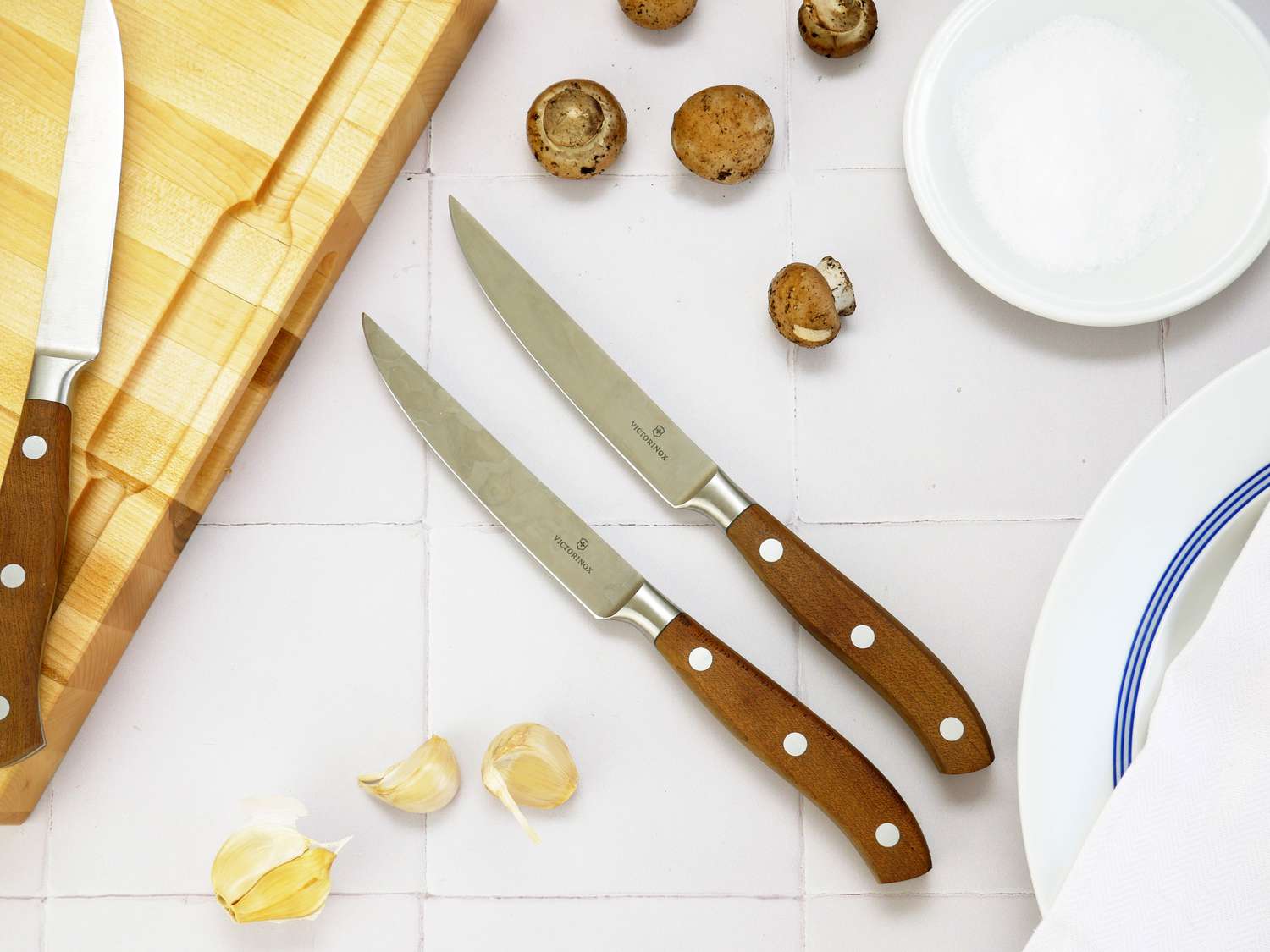 victorinox grand maitre steak knives on a white tile surface