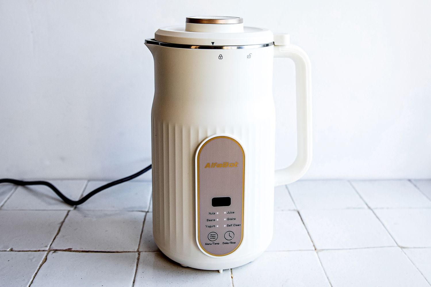 the alfabot nut milk maker on a white tile surface