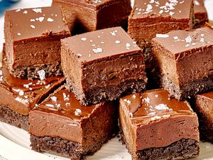 A plate with chocolate squares having a fudgy texture and a sprinkling of sea salt on top
