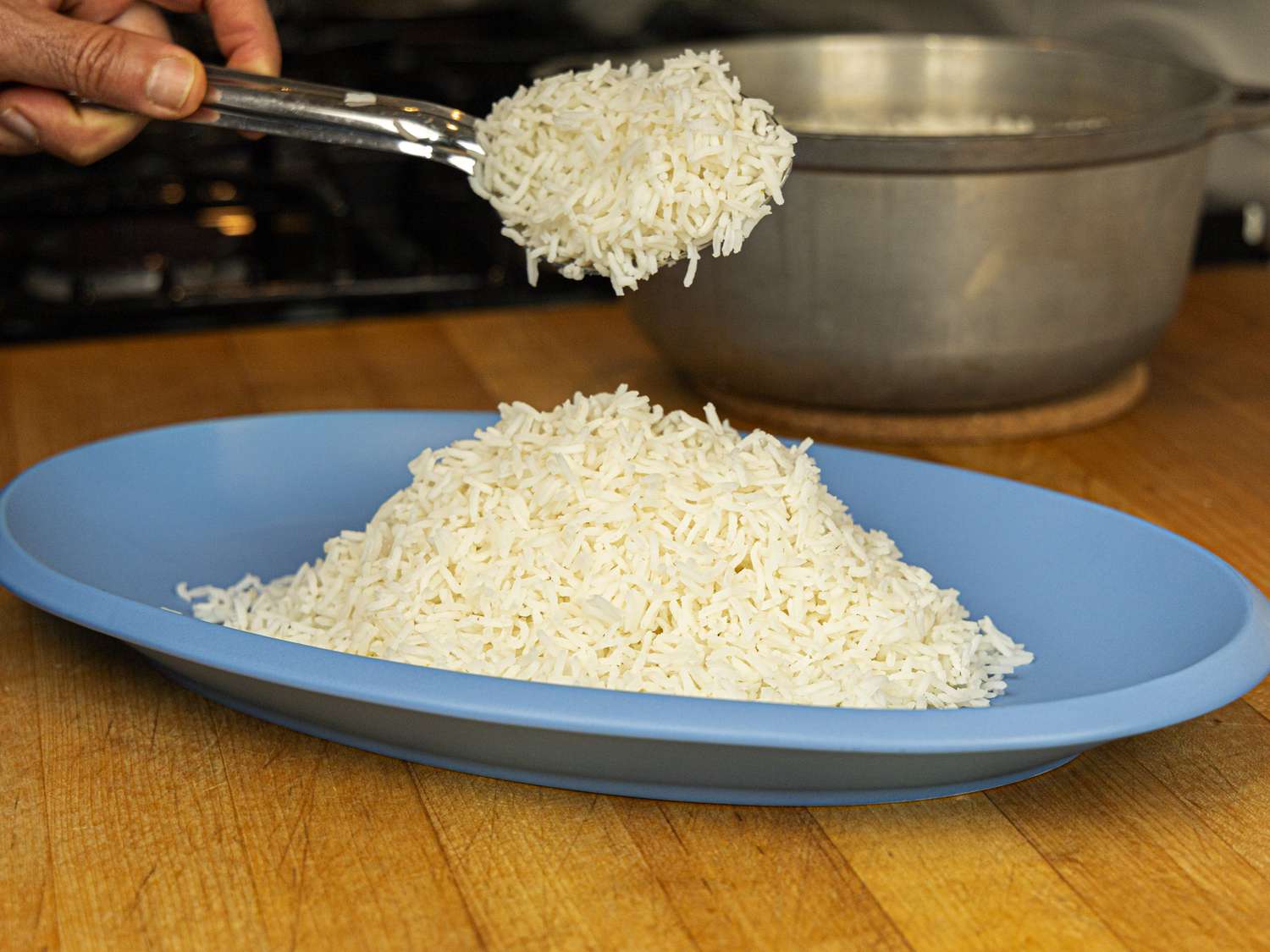 Side angle view of scooping rice onto a platter