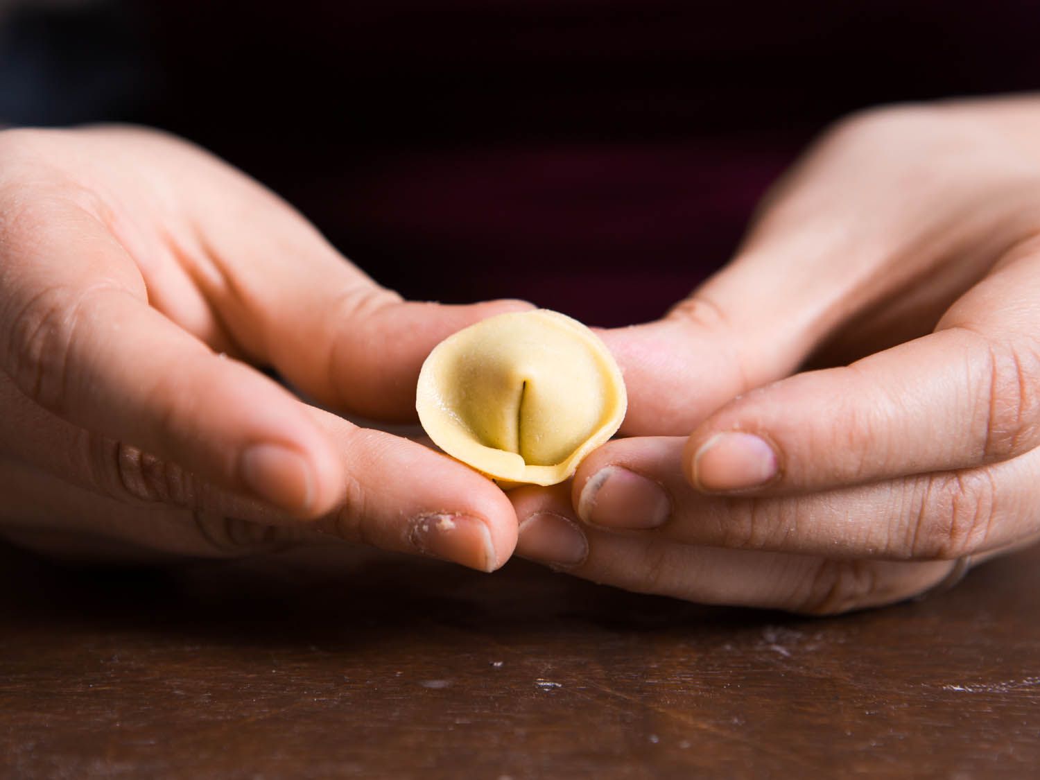 Tuckubf one corner behind the other and press together to complete shaping tortellini.